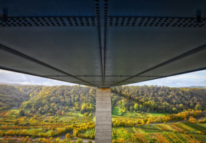 Autobahnbrücke, die sich über ein sonniges Tal erstreckt, von der Unterseite der Fahrbahn<br />
