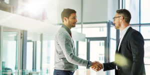 Zwei Männer in einem hellen Büro geben sich die Hände