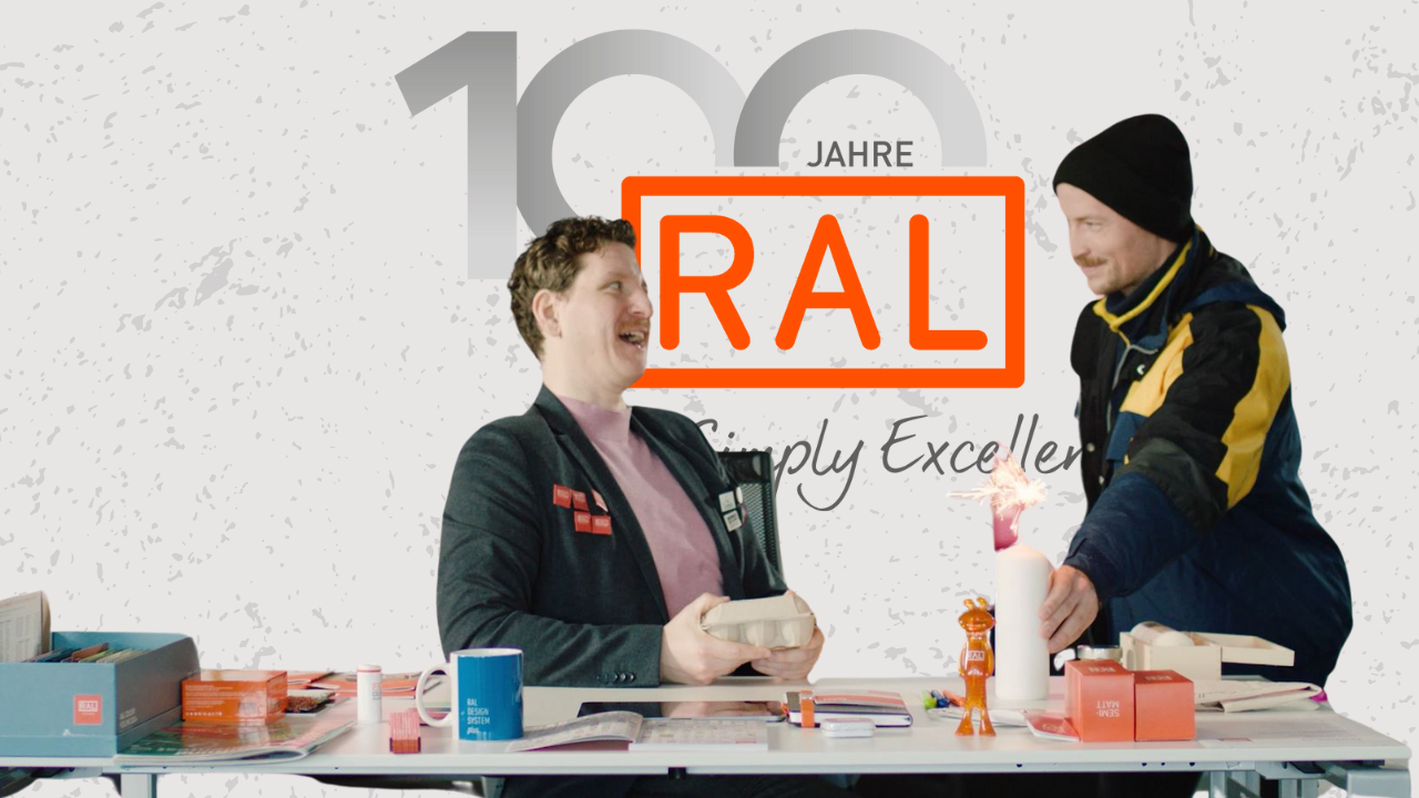 RAL als Person wird von Postboten zu 100 Jahren gratuliert.